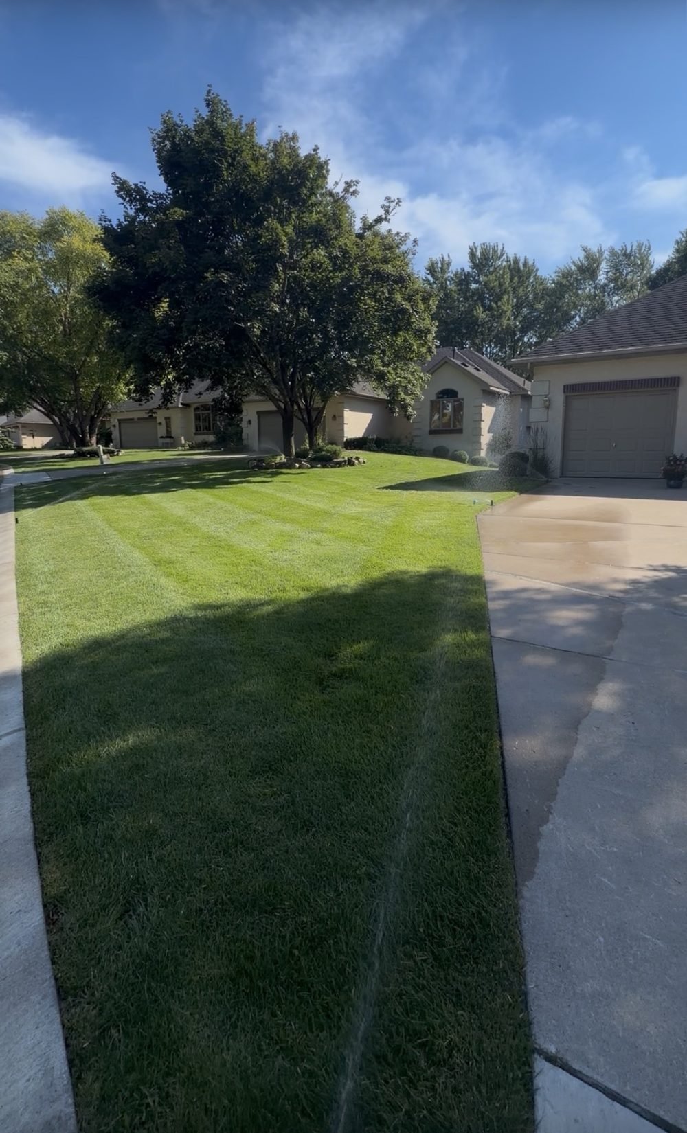 Freshly mowed, striped lawn maintained by Lindquist Outdoor Services